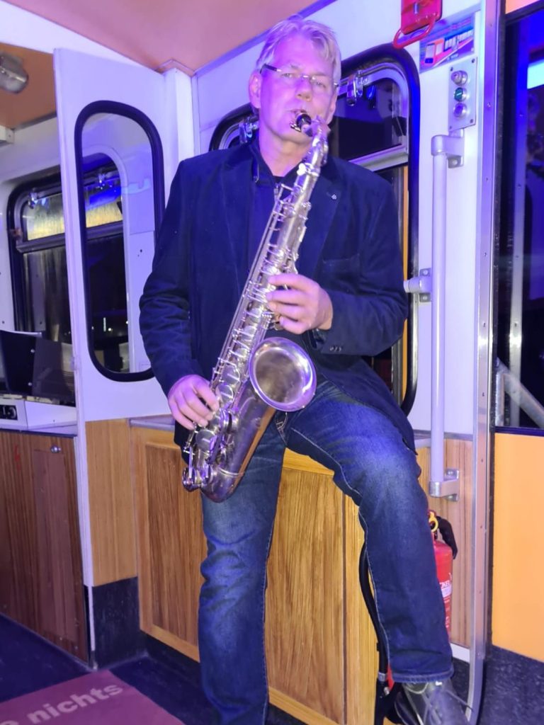 Saxophon mal in einer Wuppertaler Schwebebahn Gondel bei der AOS Stahl Deutsche Zauntechnik A1 Hausmesse in Olpe